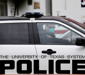 A police officer wears a mask as he speaks to a man at the check point for a coronavirus drive-through test facility, Monday, March 16, 2020, in San Antonio. According to the World Health Organization, most people recover in about two to six weeks, depending on the severity of the illness.