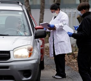 Cars line up outside the Central Outreach Wellness Center on the Northside of Pittsburgh on Monday, March 16, 2020, for drive-by testing for COVID-19. Allegheny County will begin flagging addresses of COVID-19 patients in its 911 database to alert first responders to possible exposure. (AP Photo/Gene J. Puskar)