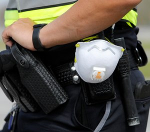 A North Charleston police officer carries a protective mask around his gun belt.