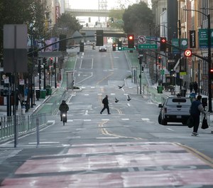 A man crosses a nearly empty street in San Francisco, Tuesday, March 17, 2020. Officials in seven San Francisco Bay Area counties have issued a shelter-in-place mandate affecting about 7 million people, including the city of San Francisco itself.