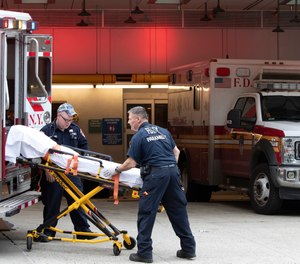 FDNY paramedics place an empty collapsible wheeled stretcher into an ambulance after delivering a patient into the emergency room at NewYork-Presbyterian Lower Manhattan Hospital, Wednesday, March 18, 2020, in New York. FDNY Commissioner Daniel Nigro said that 46 FDNY members have now tested positive for COVID-19, including firefighters, EMS providers and civilian staffers.