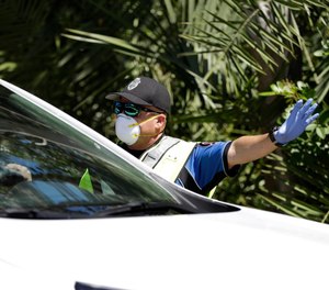 Police check cars and pedestrians at a checkpoint at the entrance to the Village of Key Biscayne, Fla., Monday, March 23, 2020. The village issued an emergency order, banning all travel, starting Monday, within the village by non-residents, with a few exceptions.