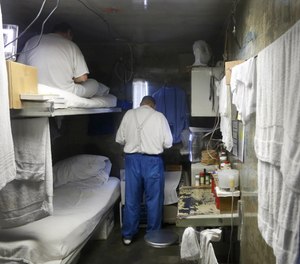 This Feb. 26, 2013 file photo, shows inmates in a cell at California State Prison, Sacramento, near Folsom, Calif. By design, correctional facilities are not able to provide appropriate social distancing.