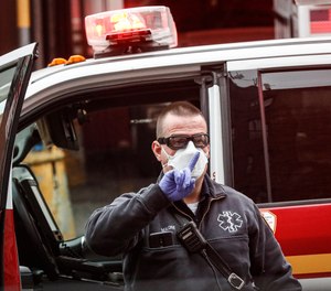 An FDNY medical worker wears personal protective equipment outside a COVID-19 testing site at Elmhurst Hospital Center, Wednesday, March 25, 2020, in New York.