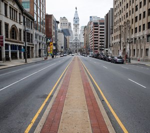 A few people travel on North Broad Street in view of City Hall in Philadelphia, Wednesday, March 25, 2020. City officials have declined to report the number of first responders affected by COVID-19, raising concerns about transparency. (AP Photo/Matt Rourke)