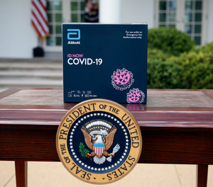 A rapid test kit for COVID-19 developed by Abbott Laboratories sits on a table ahead of a briefing by President Donald Trump about the coronavirus in the Rose Garden of the White House, Monday, March 30, 2020, in Washington. Detroit has entered into an agreement with Abbott Laboratories to order five testing machines and 5,000 test kits and plans to prioritize testing of first responders and healthcare workers.