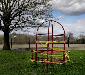 Playground equipment is wrapped in crime scene tape to prevent its use as part of the effort to slow the spread of the coronavirus Tuesday, March 31, 2020, in St. Louis.