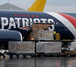 Palettes of N95 respirator masks are off-loaded from the New England Patriots football team's customized Boeing 767 jet on the tarmac, Thursday, April 2, 2020, at Logan Airport in Boston, after returning from China. The Kraft family deployed the Patriots team plane to China to fetch more than one million masks for use by front-line workers to prevent the spread of the coronavirus.