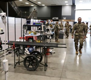 Soldiers walk through a treatment area at the site of a military field hospital, Sunday, April 5, 2020, in Seattle. The facility, which will be used for people with medical issues that are not related to the coronavirus outbreak, has more than 200 beds.
