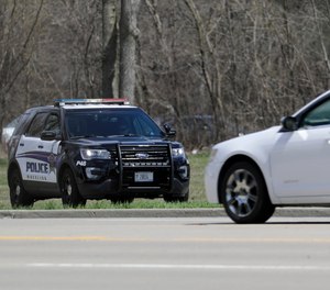 A Wheeling police officer checks the speed of the vehicles in Wheeling, Ill., Thursday, April 9, 2020.