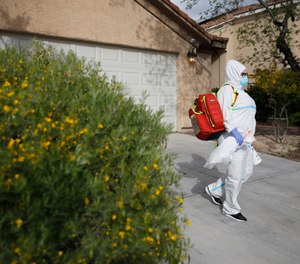 Paramedic Chelsea Monge of Ready Responders leaves a home after making a house call for a possible coronavirus patient Friday, April 10, 2020, in Henderson, Nev. Ready Responders recently began performing door-to-door COVID-19 tests in major U.S. cities including Reno, New Orleans, Las Vegas and New York City.