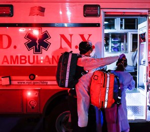 FDNY paramedics Elizabeth Bonilla, right, and Keith Kahara, left, suit up in personal protective equipment on an emergency call, Wednesday, April 15, 2020, in the Bronx borough of New York.