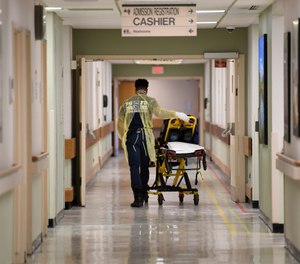 A Prince George County firefighter walks the halls of UM Laurel Medical Center in Laurel, Md., Friday, April 17, 2020. (AP Photo/Susan Walsh)