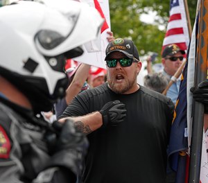 A protester argues with police in Raleigh, N.C. The protests aim to press Gov. Roy Cooper to allow businesses to reopen during the COVID-19 outbreak.