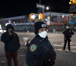 Police officers patrol a quiet street on foot Wednesday night, April 22, 2020, during the coronavirus pandemic, in the Bronx borough of New York.