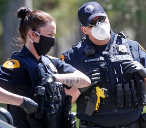 In Tuesday, April 21, 2020, photo, Salt Lake City police officers wear face masks to protect against the spread of the new coronavirus as they patrol in Salt Lake City.