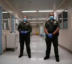 In this April 16, 2020, photo Sonia Munoz, left, and Christopher Lumpkin, custody assistants, poses for a picture at the hospital ward of the Twin Towers jail in Los Angeles.