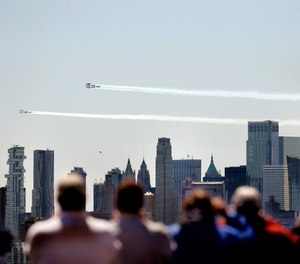 People watch as a formation of the Blue Angels and Thunderbirds flight teams pass in front of the New York City skyline as seen from in Weehawken, N.J., Tuesday, April 28, 2020. The flyover was in salute to first responders in the fight against the new coronavirus.