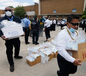 Volunteer firefighters load boxes of personal protective equipment during a health equity community event Tuesday May 12, 2020, in Richmond, Va.