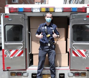 An FDNY EMT loads vehicles during the NYC Healthcare Heroes Aramark event at 435 East 26th Street on Thursday, May 14, 2020 in New York.