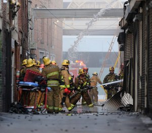 Los Angeles Fire Department firefighters work the scene of a structure fire that injured multiple firefighters, according to a fire department spokesman, Saturday, May 16, 2020, in Los Angeles.