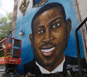 In this May 17, 2020, photo, a recently painted mural of Ahmaud Arbery is on display in Brunswick, Ga., where the 25-year-old man was shot and killed in February. It was painted by Miami artist Marvin Weeks. (AP Photo/Sarah Blake Morgan)