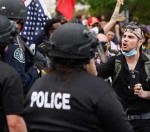 A participant in a protest over the death of George Floyd squares off with Denver Police officers Friday, May 29, 2020, in Denver.