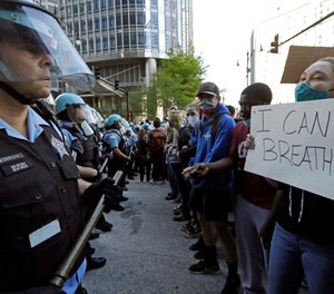 People confront police officers during a protest over the death of George Floyd in Chicago, Saturday, May 30, 2020. (AP Photo/Nam Y. Huh)