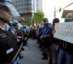 People confront police officers during a protest over the death of George Floyd in Chicago, Saturday, May 30, 2020.