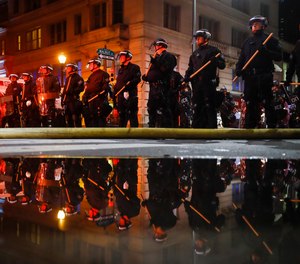 Police are reflected as they stand guard Saturday, May 30, 2020, in Philadelphia, during a protest over the death of George Floyd.
