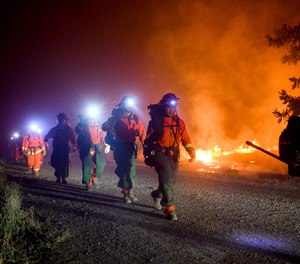 Inmate firefighters, left, battle the Quail Fire burning near Winters, Calif., on Sunday, June 7, 2020. An outbreak at a California prison has caused more than half of the state's inmate firefighting crews to be unavailable to due fire camp lockdowns.