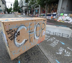 CHOP is spray painted on a barricade, Saturday, June 20, 2020, inside what has been named the Capitol Hill Occupied Protest zone in Seattle. A pre-dawn shooting near the area left one person dead and critically injured another person, authorities said Saturday.