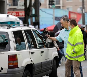 Seattle police investigators look over a car involved in a shooting, Monday, June 29, 2020, in Seattle, where streets are blocked off in what has been named the Capitol Hill Occupied Protest zone. A 16-year-old boy was killed and a 14-year-old boy was wounded in the shooting.