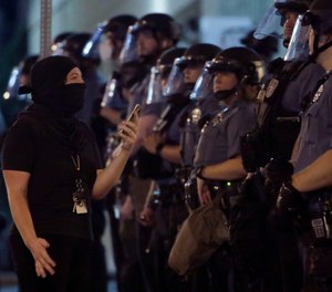 A woman confronts a line of police as protesters gathered at the police headquarters in downtown Kansas City, Mo. Friday, July 17, 2020. Demonstrators were demanding police reforms and an end to Operation Legend, a federal initiative that will deploy 225 federal law enforcement agents to combat crime in the city.