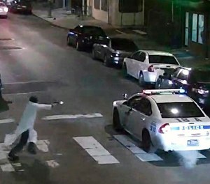 In this Jan. 7, 2016, image made from a video provided by the Philadelphia Police Department, a gunman runs toward a police car driven by Philadelphia police officer Jesse Hartnett in Philadelphia. (Philadelphia Police Department via AP, File)