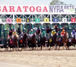 Race fans watch horses break from the starting gate during the first race on opening day of the season at Saratoga Race Course in Saratoga Springs, N.Y., Friday, July 22, 2016. An attorney representing residents has argued against building a $6.6 million fire/EMS station near the track due to zoning issues and concerns it will disturb the horses. (AP Photo/Hans Pennink)