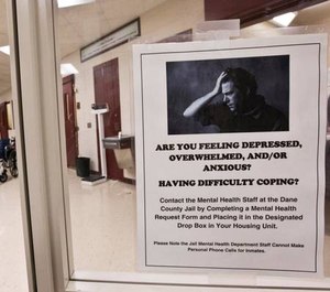 A mental illness poster is seen in the intake room of the Dane County Jail Tuesday, Sept. 16, 2014, in Madison, Wis. (AP Photo/Morry Gash)