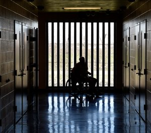 A patient in the medical wing of the Kentucky State Reformatory, looks out the window at the yard Thursday, April 17, 2014, in LaGrange, Ky.