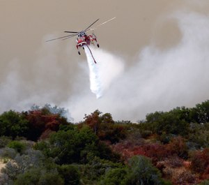 Helicopter drop of the Sherpa Fire in Santa Barbara County, Calif., Friday, June 17, 2016. An appeals court ruling means CAL FIRE can proceed with its suit against Presbyterian Camp and Conference Centers for the costs of fighting the massive wildfire that burned 7,500 acres. (AP Photo/Nick Ut)