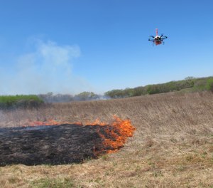 A drone designed to ignite controlled grass fires comes in for a landing in a field at the Homestead Monument of America in Beatrice, Neb., on Friday, April 22, 2016.