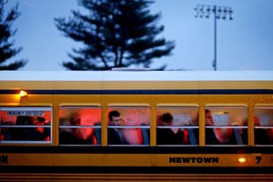 People arrive on a school bus at Newtown High School for a memorial vigil attended by President Barack Obama for the victims of the Sandy Hook Elementary School shooting in Newtown, Conn. (AP Photo/David Goldman, File)