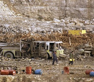 Investigators search through a highway construction site, Nov. 29, 1988 in Kansas City, Missouri where an explosion killed six firefighters. One of the five convicted in the deadly blast is requesting release, claiming her health problems put her at risk of becoming seriously ill or dying from COVID-19.