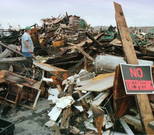 John Testaverde, plant manager of the Gloucester, Mass., Fisherman's Wharf looks over the charred remains of the wharf, Friday, Aug. 21, 1998, which was destroyed in a four-alarm fire. (Photo/AP, Lisa Poole)