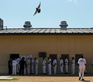 In this June 18, 2015, file photo, prisoners stand in a crowded lunch line during a prison tour at Elmore Correctional Facility in Elmore, Ala. (AP Photo/Brynn Anderson, File)