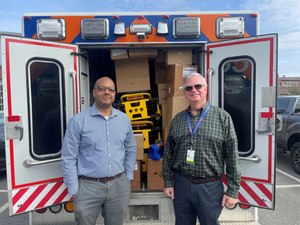 Richmond Ambulance Authority’s Media Manager, Mark Tenia (left) and CEO, Chip Decker (right), stand before an ambulance loaded with supplies being donated to Ukraine.