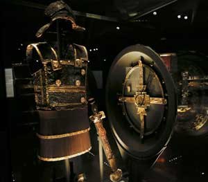 The gold-decorated iron body armor, sword, and ceremonial shield of ancient Greek King Philip II of Macedon is displayed at Vergina museum, northern Greece. Modern body armor worn today by police is lighter and more comfortable, but serves precisely the same purpose as armor from ancient history.
