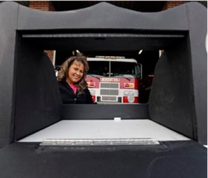 Monica Kelsey, firefighter and medic who is president of Safe Haven Baby Boxes Inc., poses with a prototype of a baby box, outside her fire station in Woodburn, Ind. (AP Photo/Michael Conroy)