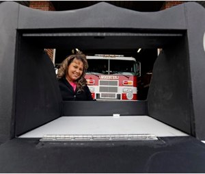 Monica Kelsey, firefighter and medic who is president of Safe Haven Baby Boxes Inc., poses with a prototype of a baby box, where parents could surrender their newborns anonymously, outside her fire station in Woodburn, Ind.. (AP Photo/Michael Conroy)