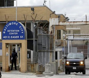 In this Thursday, June 6, 2013, file photo, a prisoner transport van departs from the Baltimore City Detention Center, in Baltimore where a contraband conspiracy revealed the widespread corruption inside the facility involving the Black Guerilla Family. (AP Image)