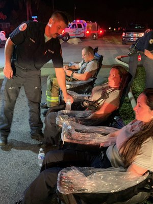 Two firefighters from the first-in medic unit, plus a firefighter from the first engine in, use the iced-arms trays to help lower core body temperatures.